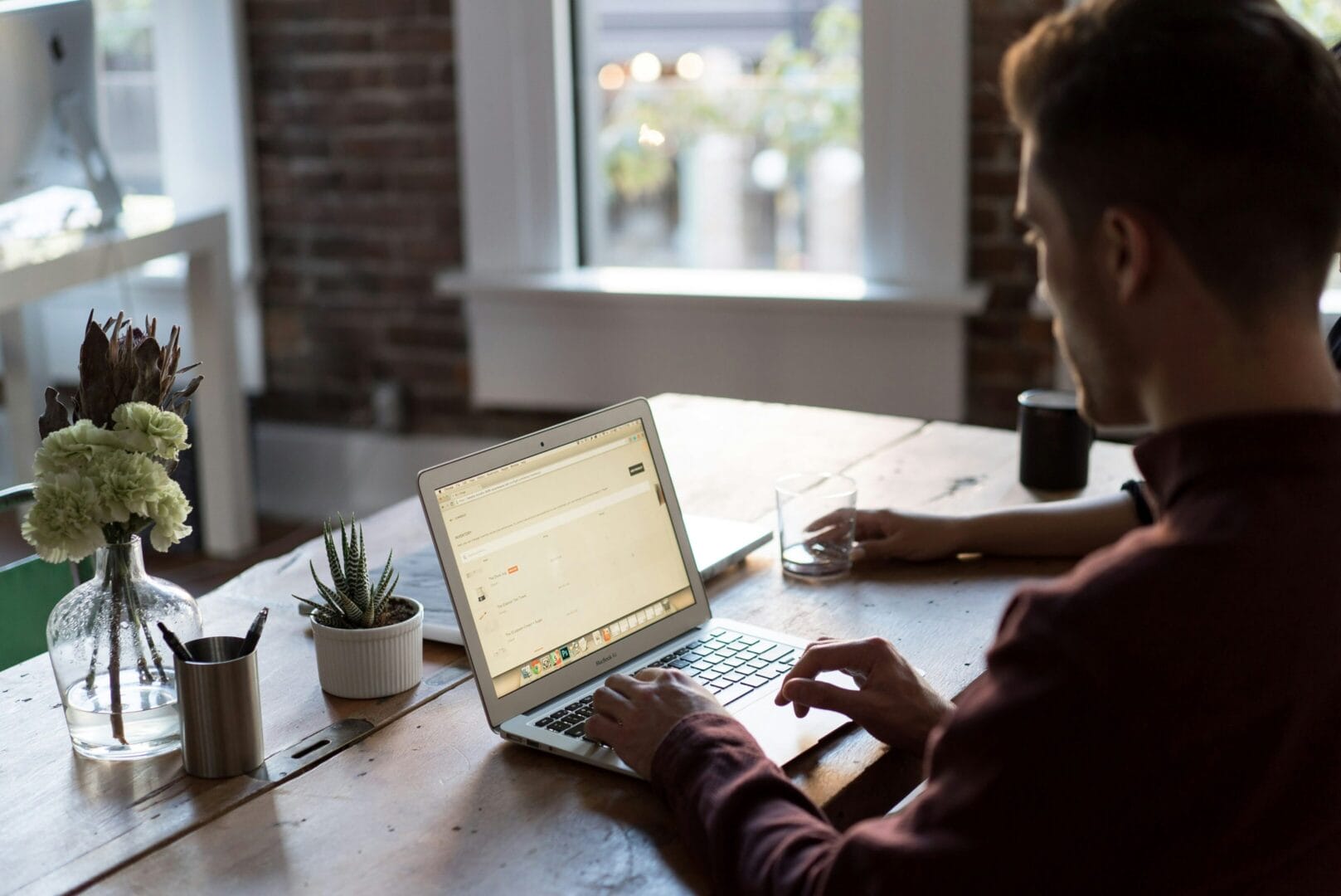 Man working on his laptop on a wooden desk