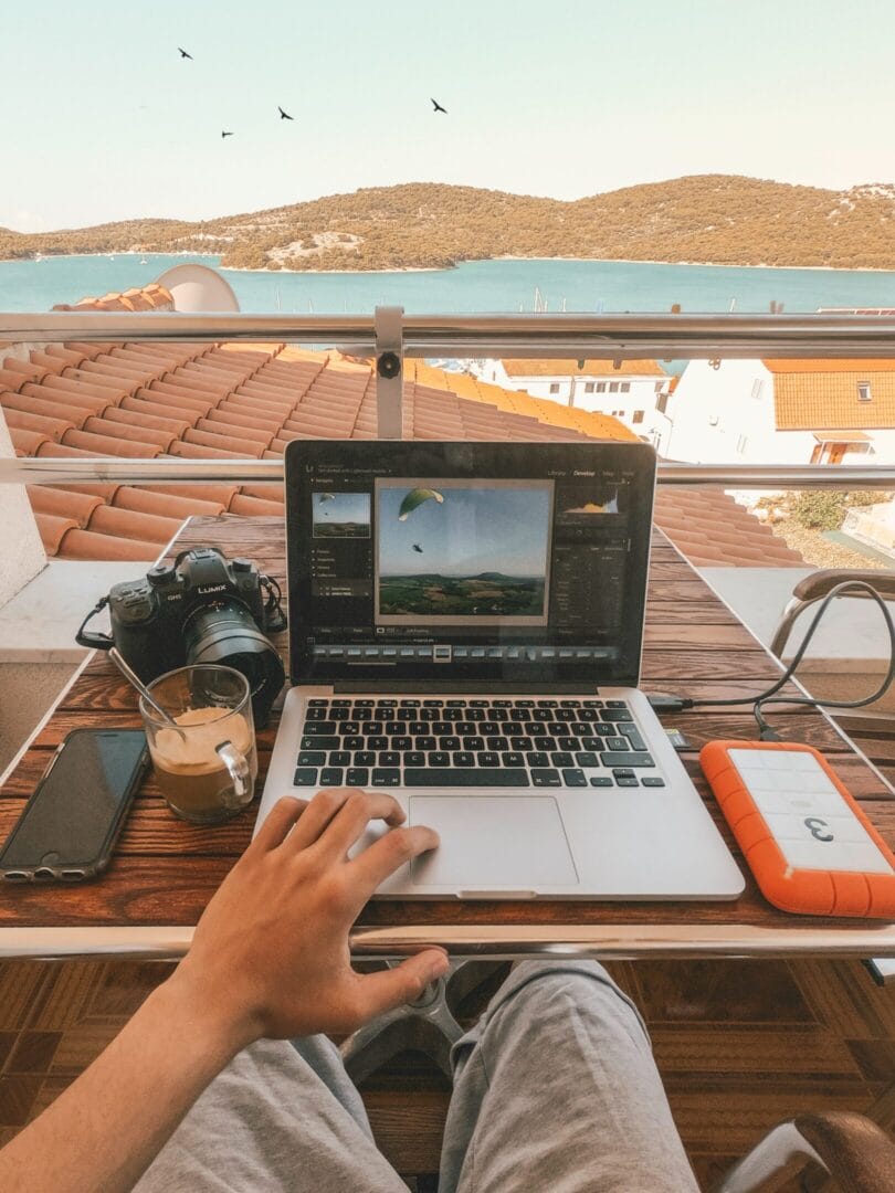 Man working on a laptop overlooking a scenic view