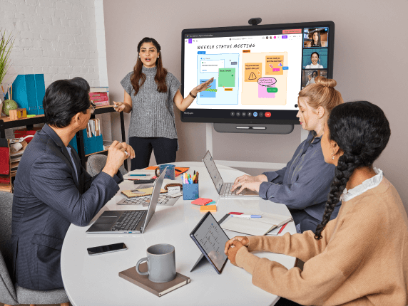 A group of employees working around an interactive display together