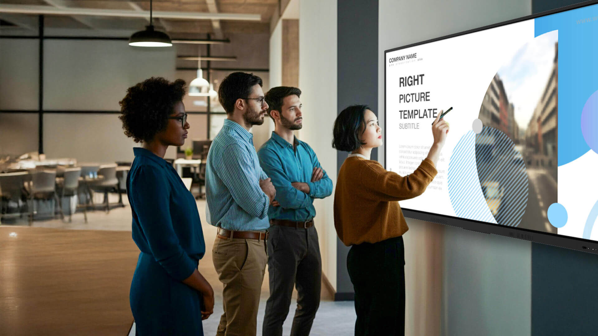 a team standing around a screen collaborating on work